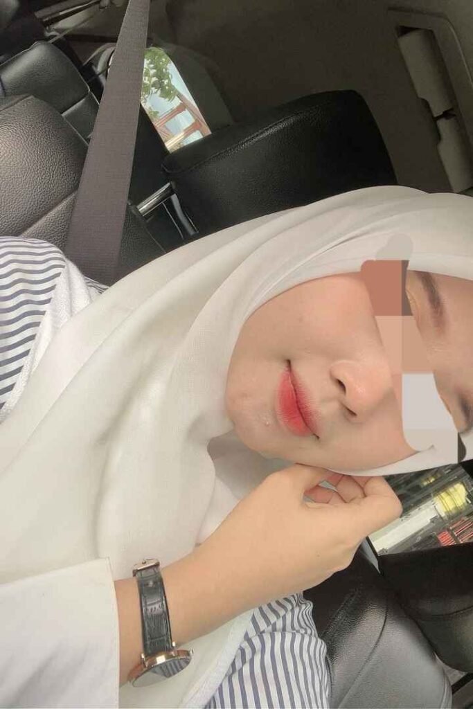 Eika, a stunning Malay Call Girl in KL, wearing a hijab and seatbelt in a car. Malaysia Escort Services